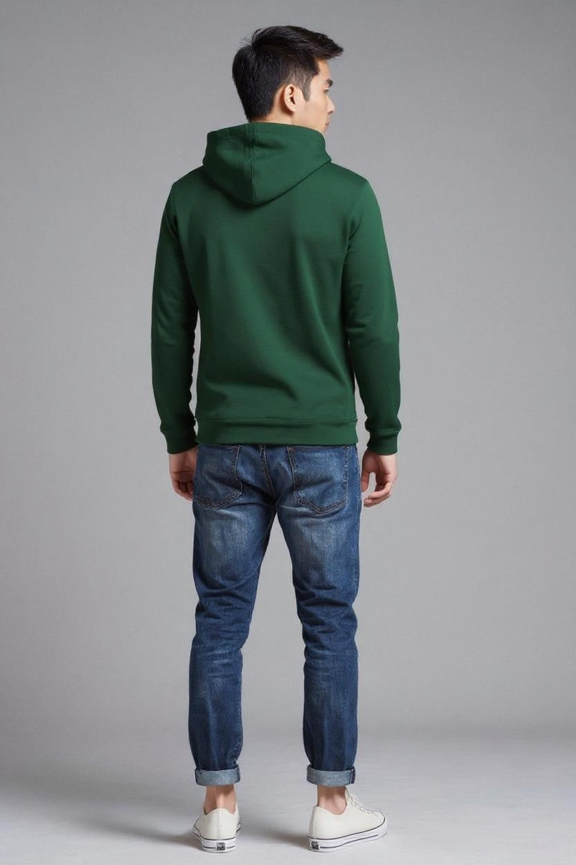 Person wearing a green hoodie and blue jeans on a gray background