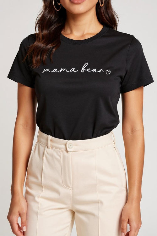 Person wearing a black t-shirt with 'mama bear' text on a plain background