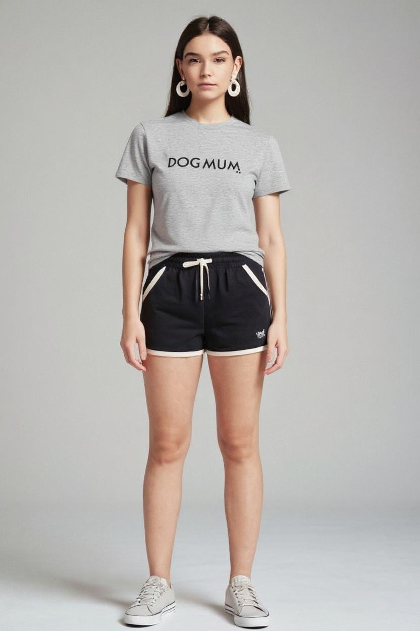 Woman wearing a gray 'DOG MUM' t-shirt and black shorts on a plain background