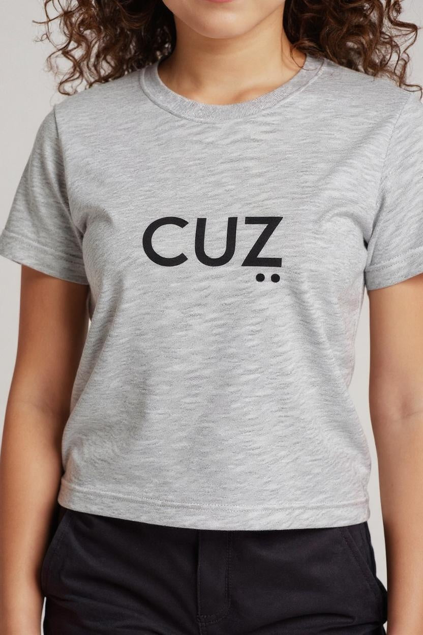 Person wearing a gray t-shirt with 'CUZ' printed on it against a plain background
