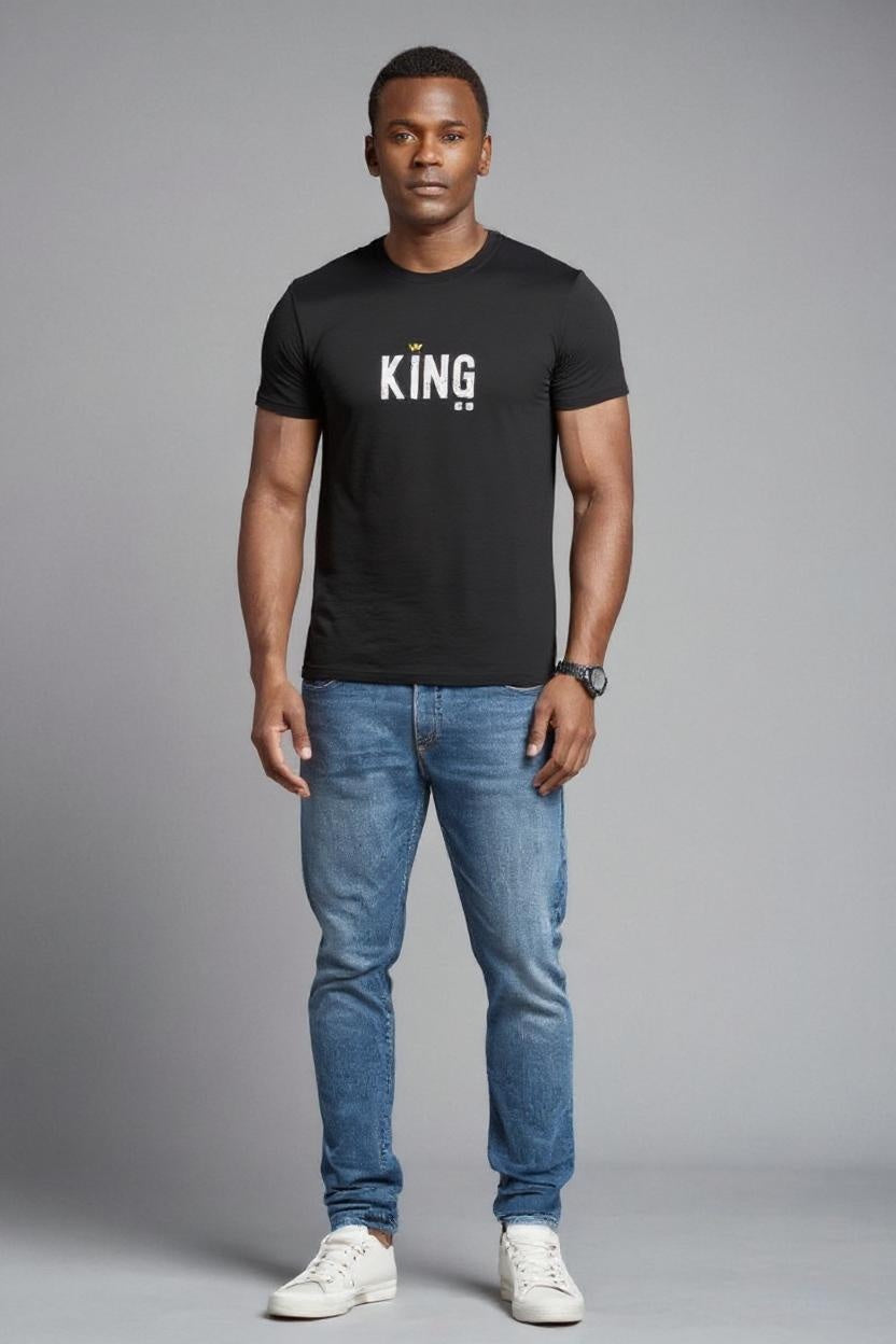 Man wearing a black t-shirt with 'KING' text, blue jeans, and white sneakers on a gray background